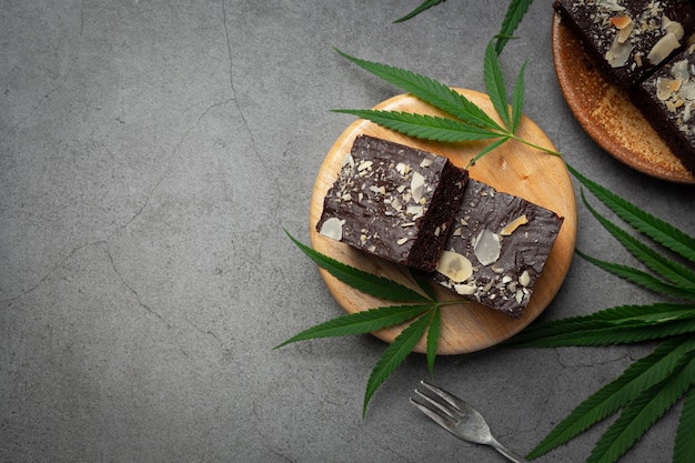 Cannabis brownies and cannabis leaves put on wooden cutting board