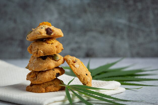 Cannabis cookies and cannabis leaves put on white napkin