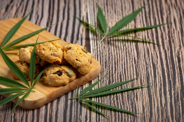 Foto gratuita biscotti alla cannabis e foglie di cannabis messe sul tagliere di legno