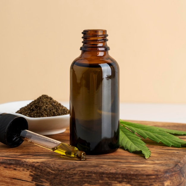 Free photo cannabis leaf and oil bottle arrangement