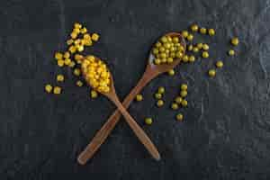 Free photo canned corns and green peas with spoons.