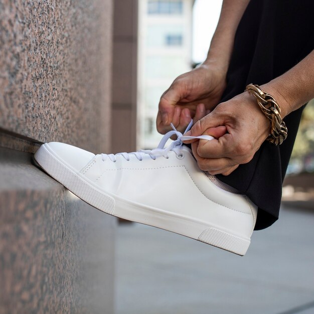 Canvas sneakers white model tying shoelaces apparel ad