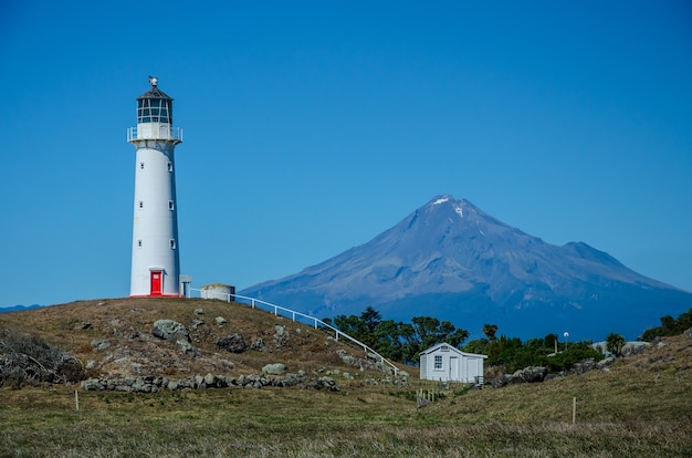 無料写真 ニュージーランドのプンガレフにあるタラナキ山の背後にあるケープエグモント灯台