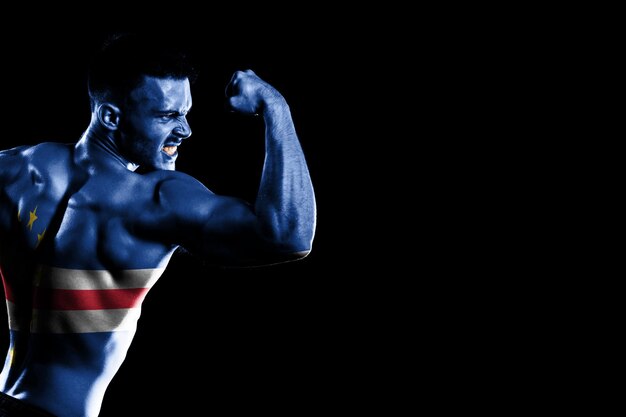 Cape Verde flag on handsome young muscular man black background