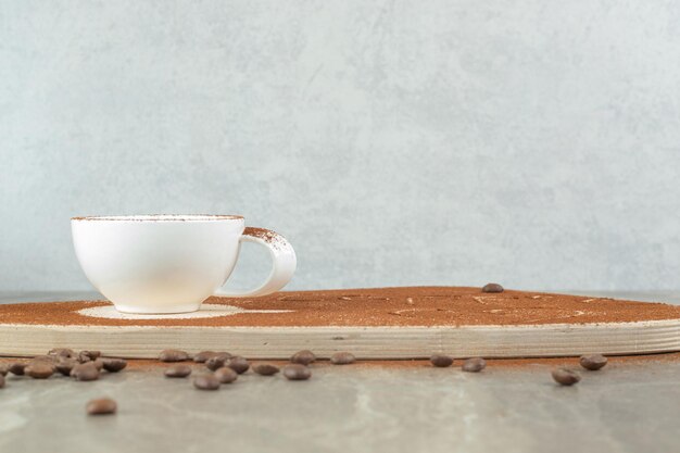 Cappuccino on wooden board with coffee beans. 