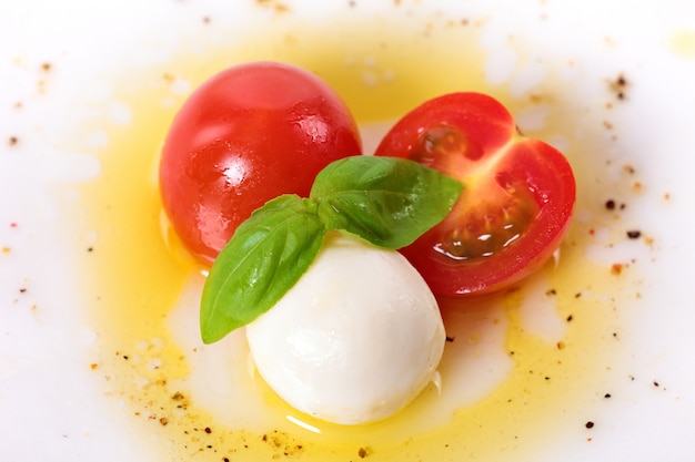 Free photo caprese salad with mozzarella cherry tomatoes and basil leaves