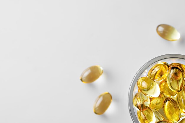 Capsules of fish oil in a glass bowl