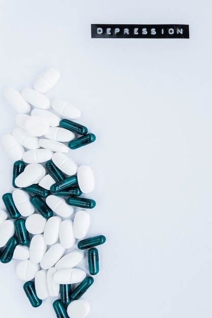 Foto gratuita capsule e pillole su sfondo bianco con testo di depressione