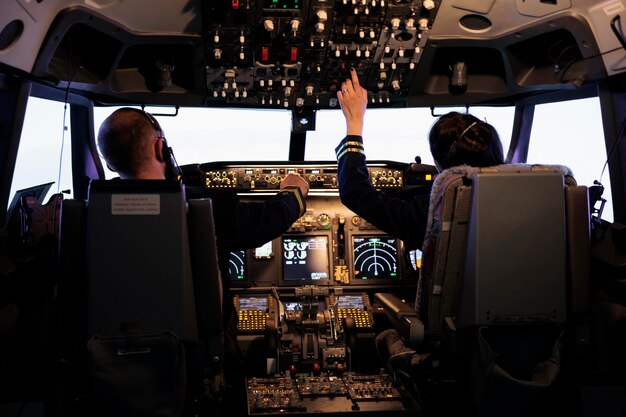 Captain and woman copilot getting ready to fly airplane and takeoff with dashboard navigation in cockpit command. Airline crew fixing altitude level and with control panel buttons, flying plane.