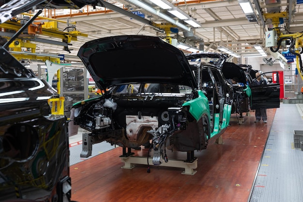 Car bodies are on assembly line Factory for production of cars Modern automotive industry A car being checked before being painted in a hightech enterprise