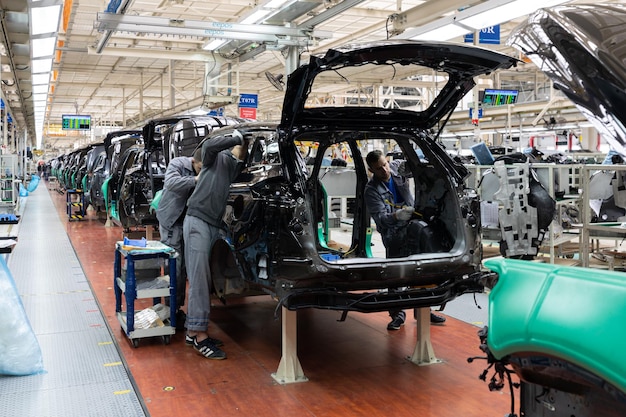 Foto gratuita le carrozzerie sono in catena di montaggio fabbrica per la produzione di automobili industria automobilistica moderna un'auto viene controllata prima di essere verniciata in un'impresa hightech