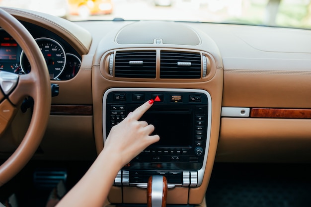 Car dashboard. Radio closeup. Woman sets up radio