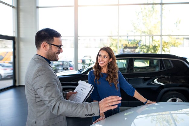 car dealer presenting new car to the customer