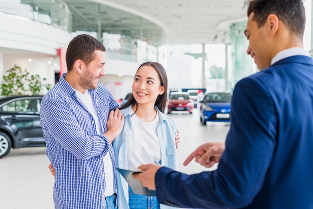 Car dealer talking to clients