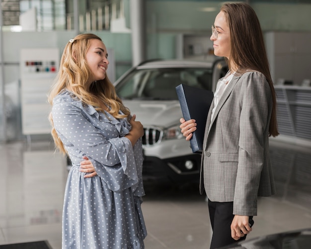 Car dealer talking with beautiful woman