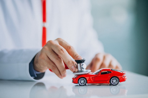 Free photo car doctor with stethoscope in a car showroom