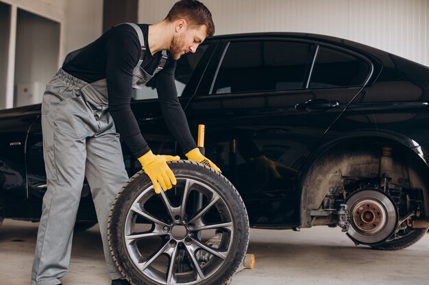 Car mechanic changing wheels in car