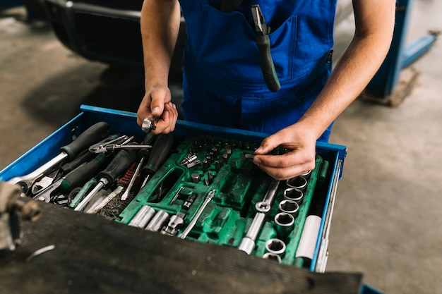 Car mechanic choosing spanners 