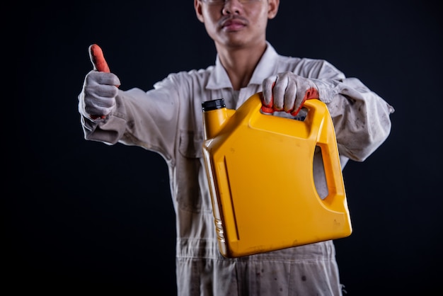 Free photo car mechanic wearing a white uniform stand holding wrench