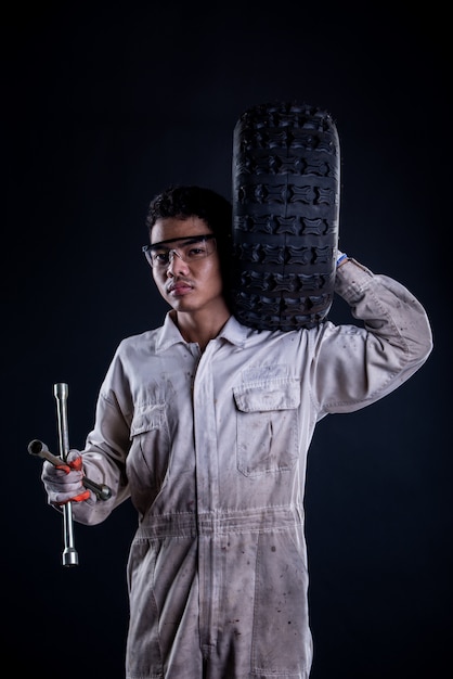 Free photo car mechanic wearing a white uniform stand holding wrench