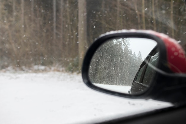 Car mirror during a road trip in winter