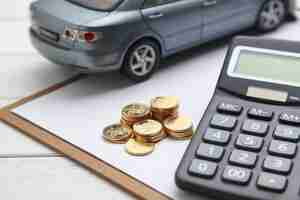 Free photo car model,calculator and coins on white table