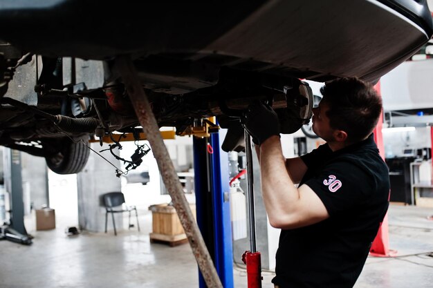 Car repair and maintenance theme Mechanic in uniform working in auto service