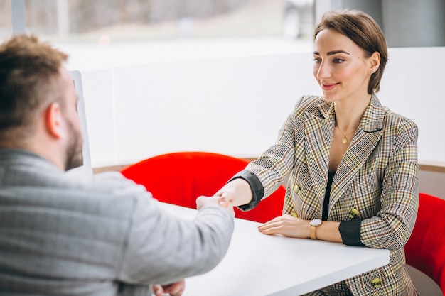 Foto gratuita commessa dell'automobile che parla con il cliente