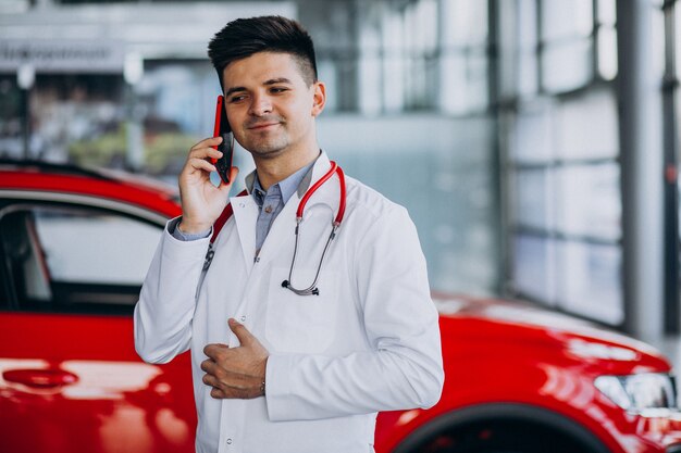 car technician with stethoscope in a car showroom talking on the phone