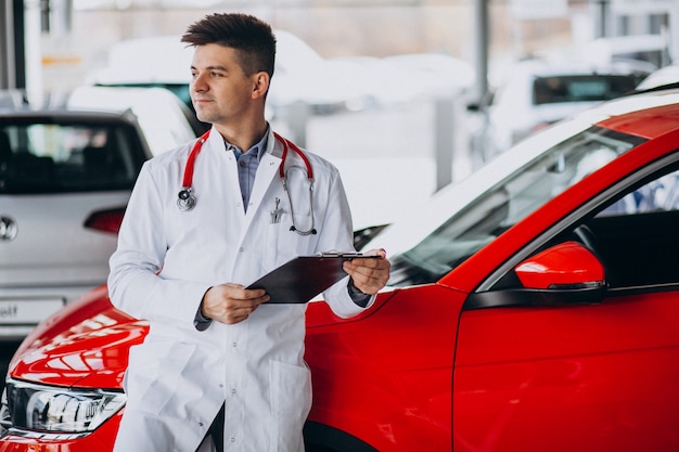 car technician with stethoscope in a car showroom