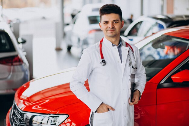 car technician with stethoscope in a car showroom