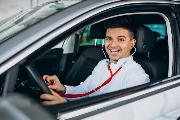 car technician with stethoscope in a car showroom