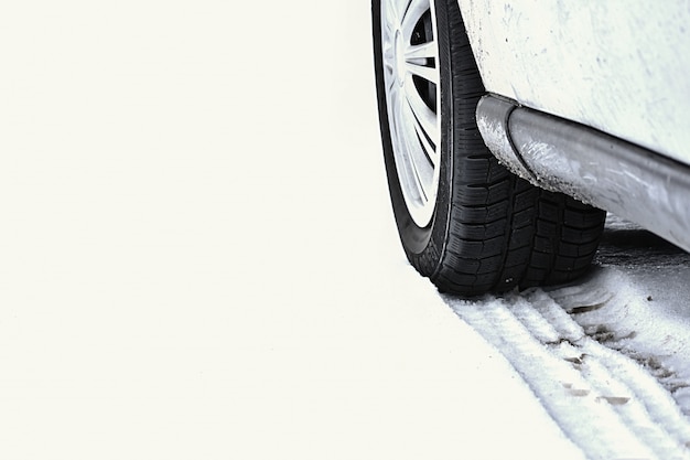 Car in winter. Tire on a snowy road in bad weather.