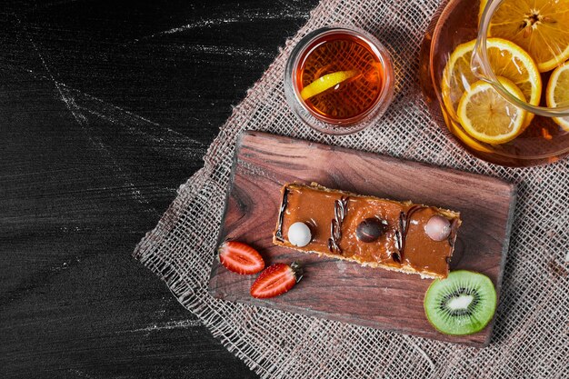 Caramel cake slice on a wooden platter .