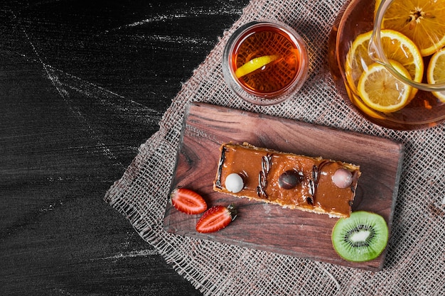 Caramel cake slice on a wooden platter .