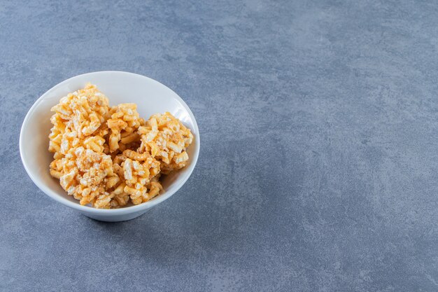 Caramel candies in a bowl , on the marble background.