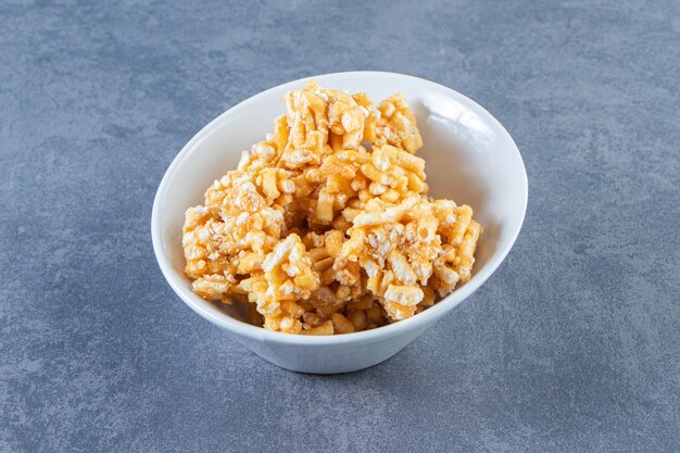 Caramel candies in a bowl on the marble surface