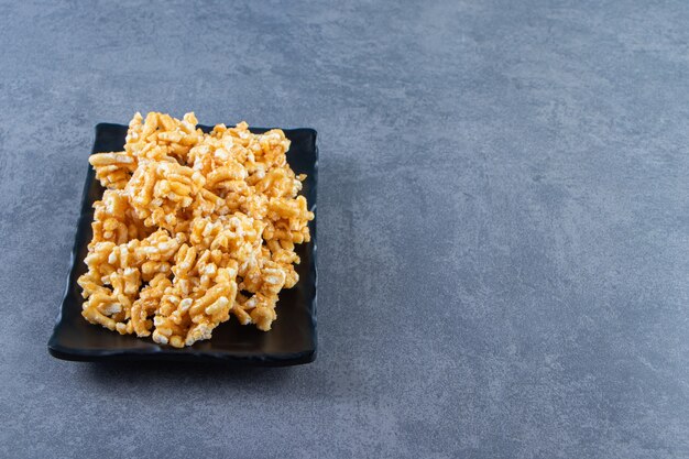 Caramel candies on a plate , on the marble background.