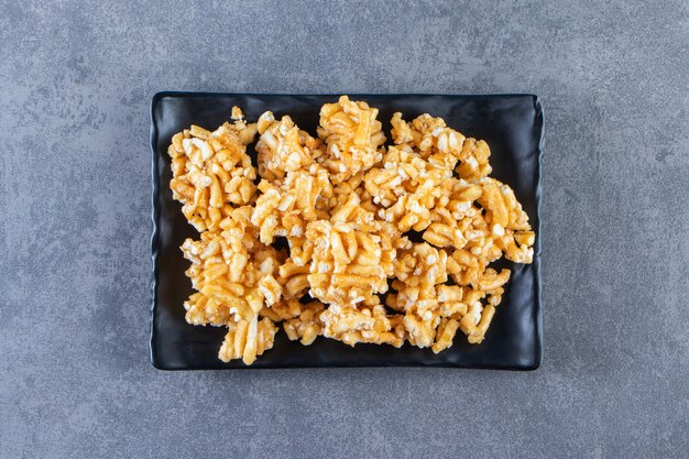 Caramel candies on a plate , on the marble background.