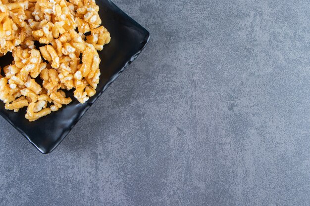 Caramel candies on a plate on the marble surface