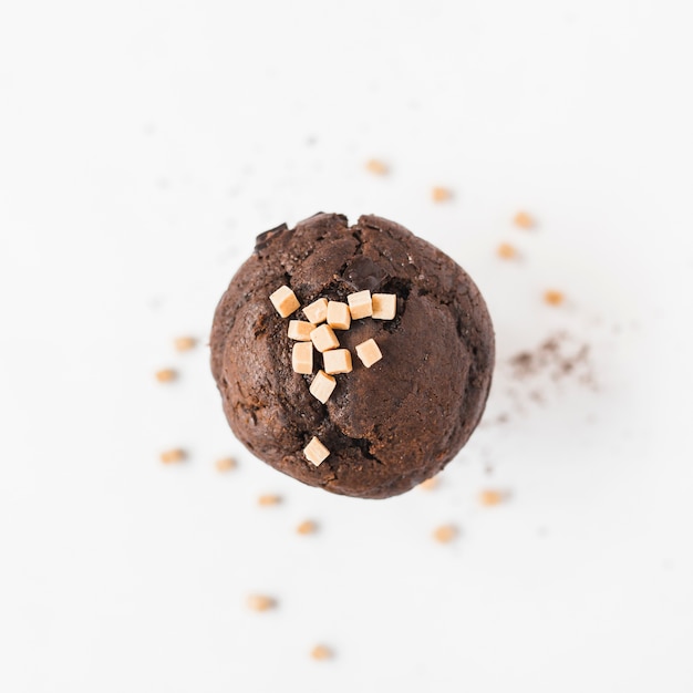 Caramel Candy Cubes on a Brown Cupcake Against a White Background