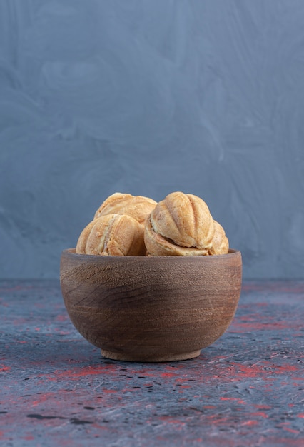 Caramel filled cookie balls in a bowl on abstract table.