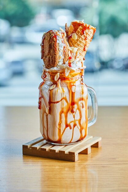 Caramel ring milkshake in the wooden plate on the marble table.