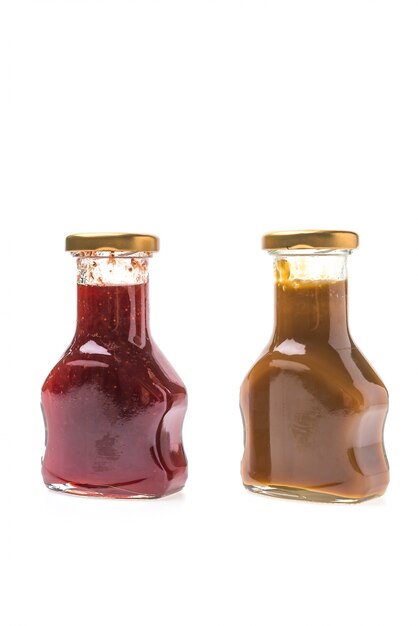 Caramel sauce and strawberry jam bottles