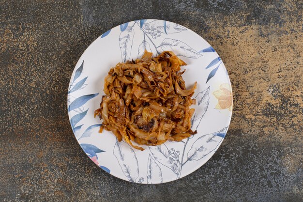 Caramelized onion pieces on colorful plate. 