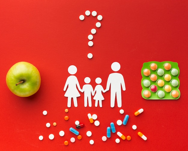 Free photo cardboard family shapes with pills and healthy food