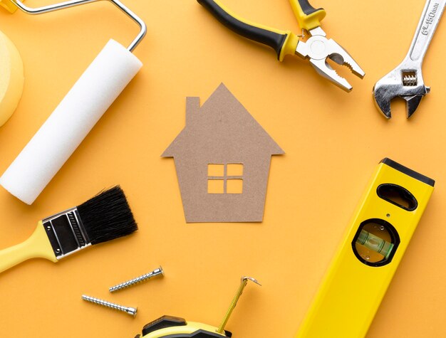 Cardboard house with tools flat lay