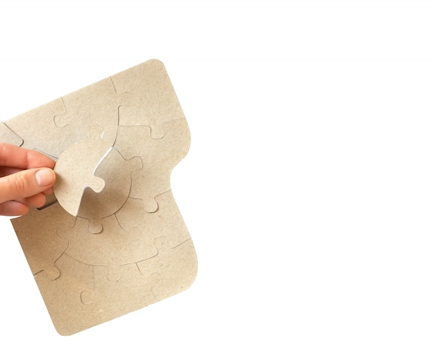 Cardboard puzzles in female hands, close up.