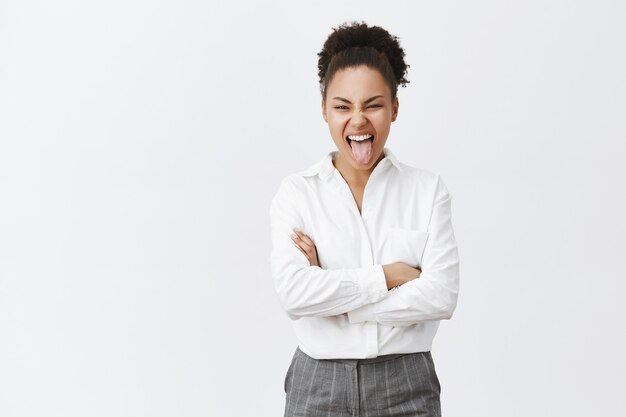 Carefree african-american businesswoman showing tongue and having fun