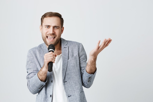 Carefree bearded performer singing song into microphone